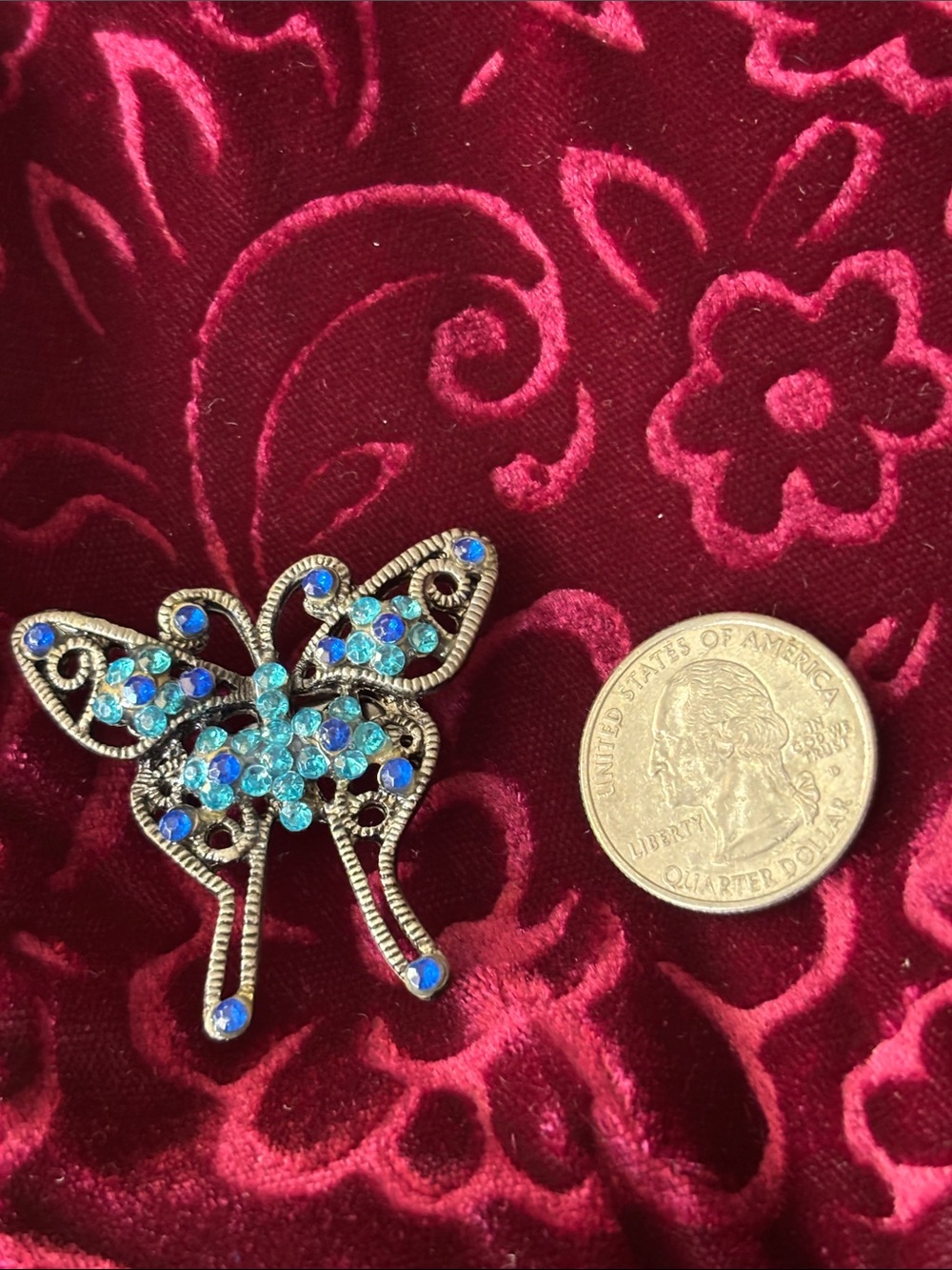 SILVERTONE BUTTERFLY BROOCH adorned with blue and light blue rhinestone.